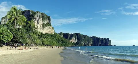 Limestone cliffs, palm trees and the shore at Ao Nang in Krabi