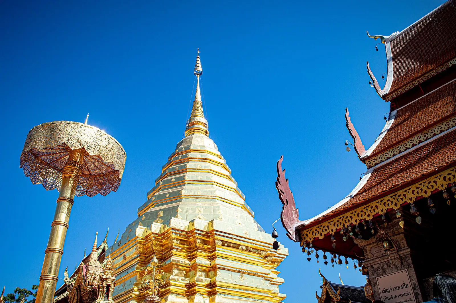 The golden chedi of Wat Phra That Doi Suthep under a blue sky