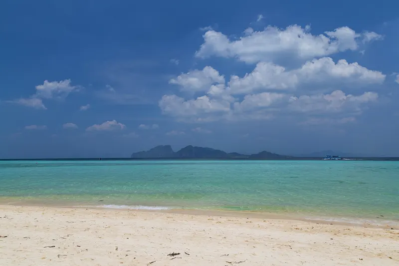 White sand and turquoise water at Ko Kradan with limestone islands on the horizon