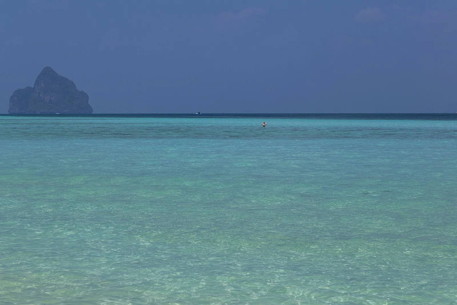 A limestone island rising from clear turquoise sea off Ko Kradan