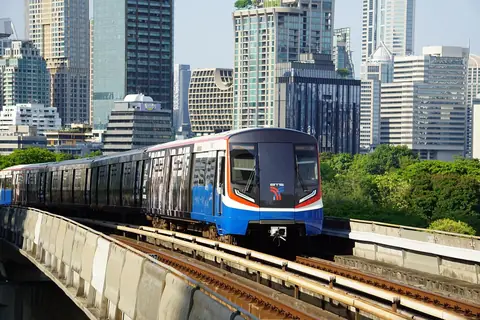 Una BTS Skytrain che corre sopra le strade di Bangkok accanto a torri cittadine