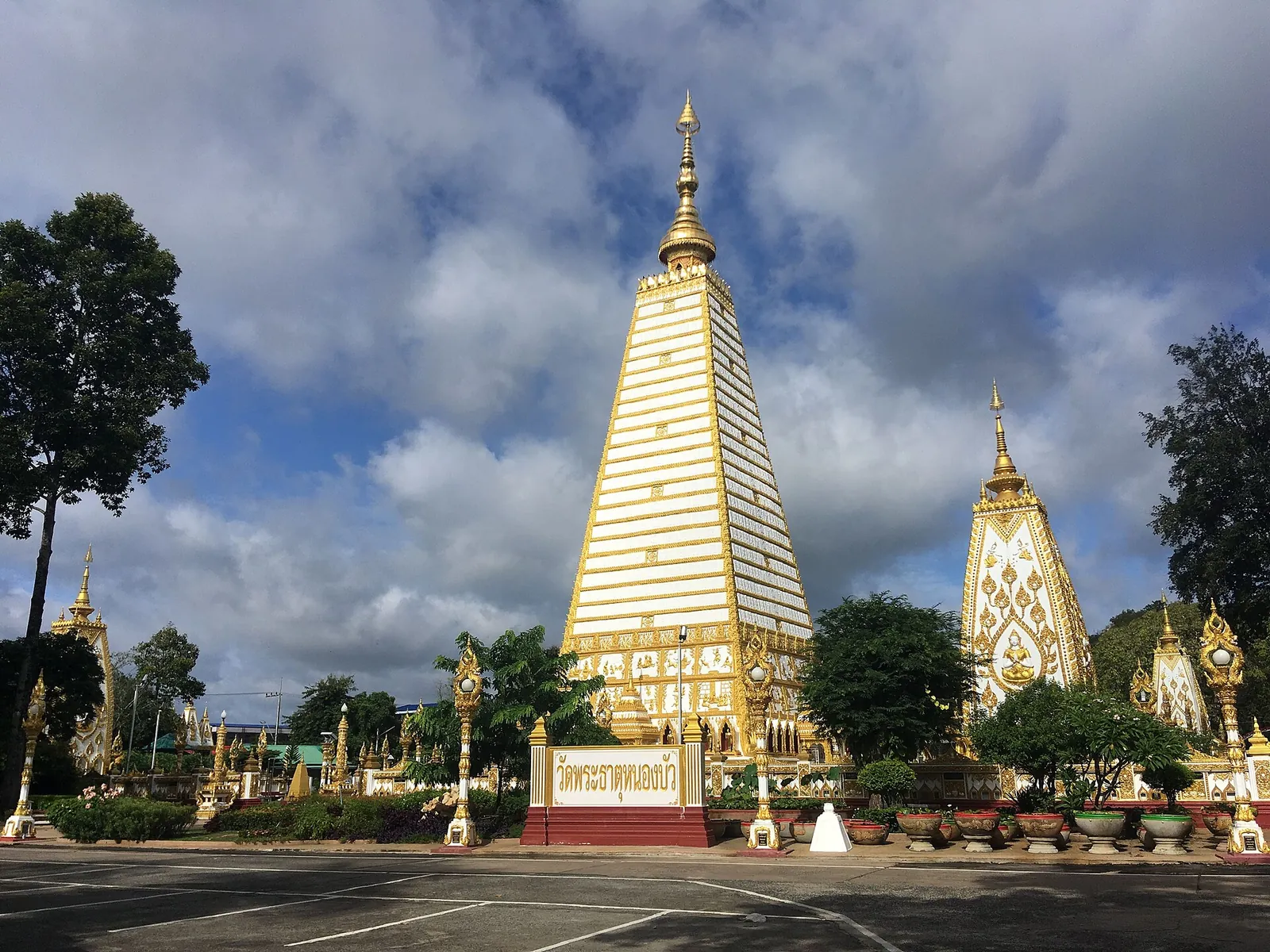 The white-and-gold chedi of Wat Phra That Nong Bua under a cloudy sky