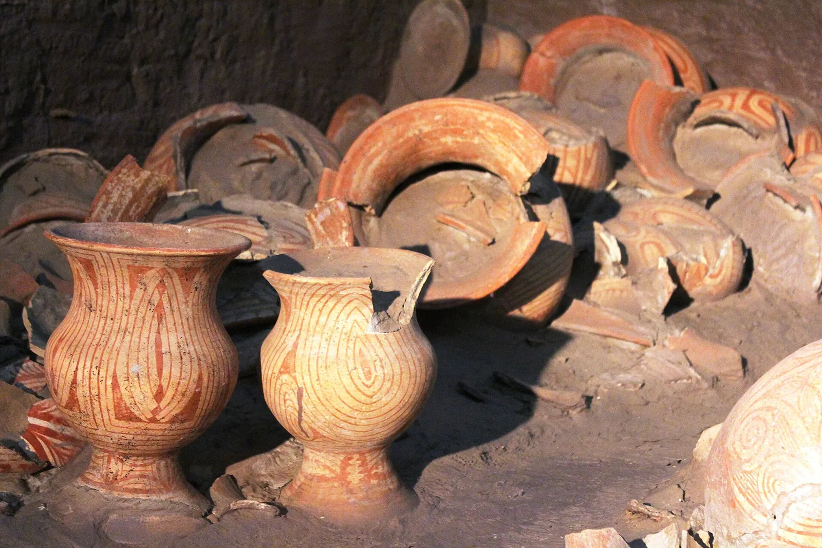 Prehistoric red-painted Ban Chiang pottery displayed in an excavation pit at the museum