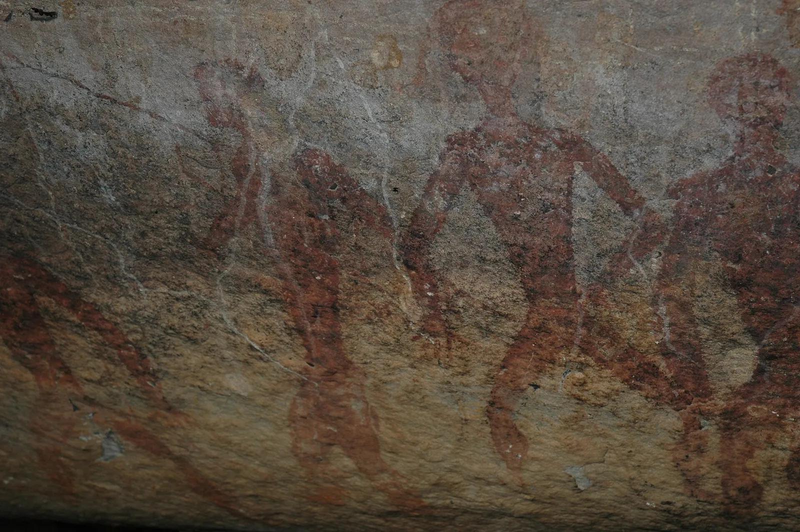 Faded red prehistoric paintings on a rock shelter wall at Tham Khon, Phu Phrabat