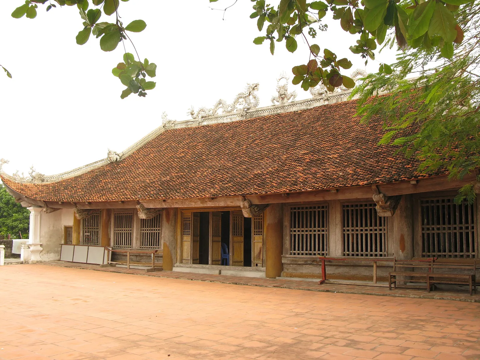 The old wooden Quan Lan communal house with a tiled roof and wooden columns on Quan Lan Island