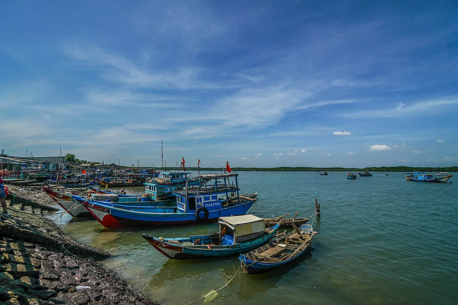 Wooden fishing boats moored in shallow water at a fishing harbour in Can Gio
