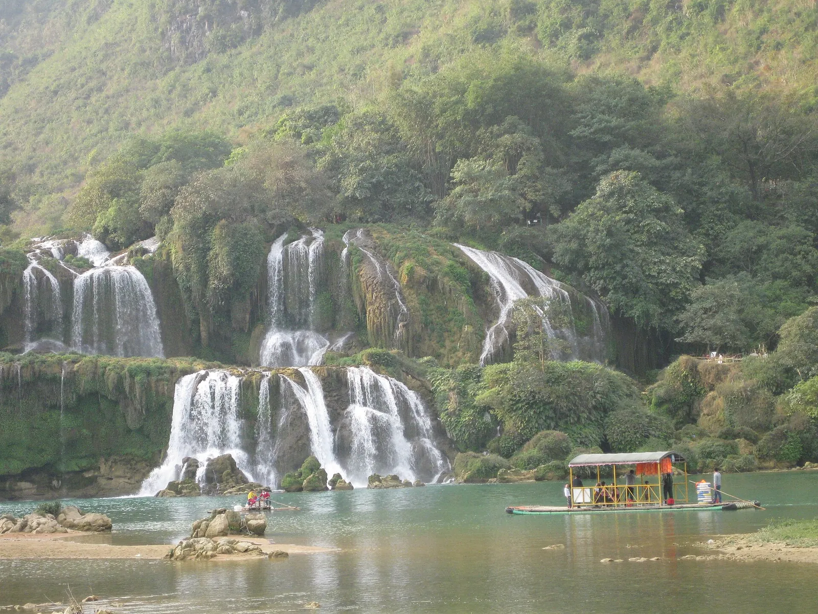 A covered raft on the river below the cascades of Ban Gioc Waterfall