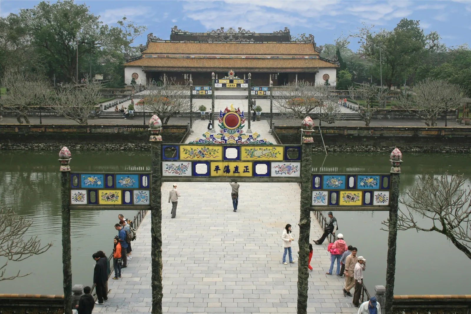 Stone walkway and ornamental gate leading across a pond to the Thai Hoa Palace in Hue's Imperial City