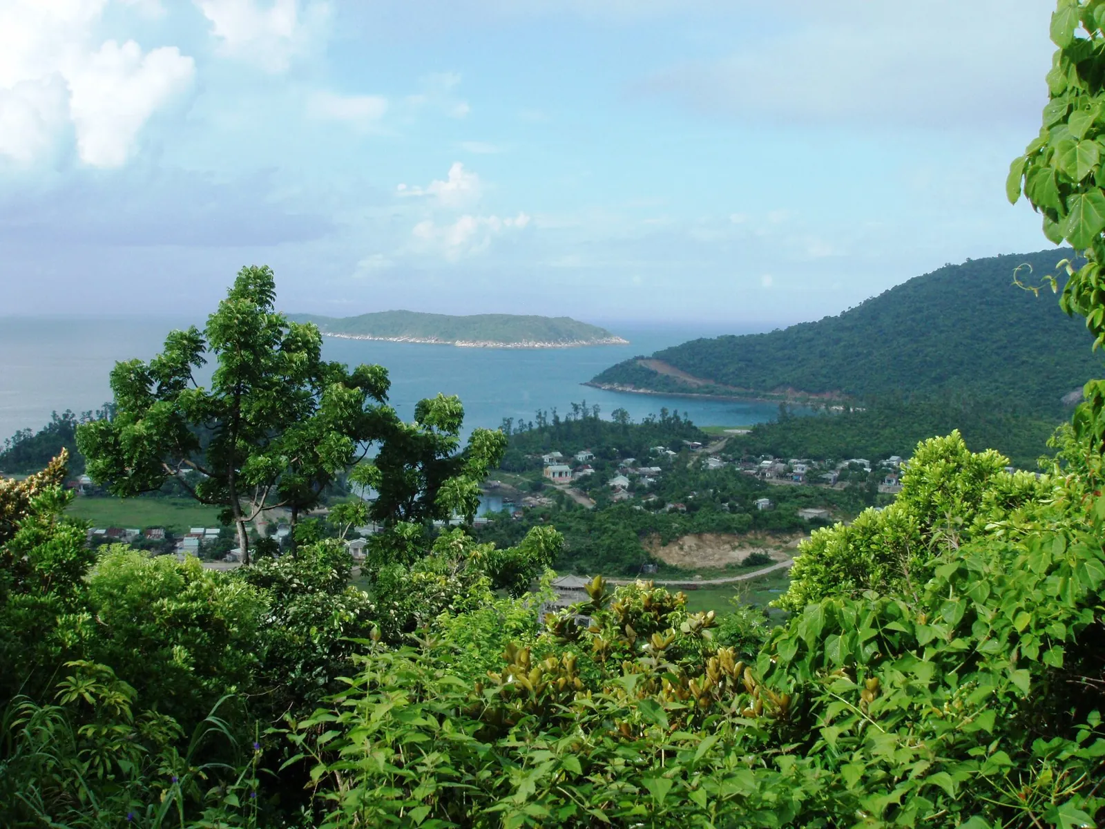 View from a forested hillside over the village and bays of Hon Lao, Cham Islands