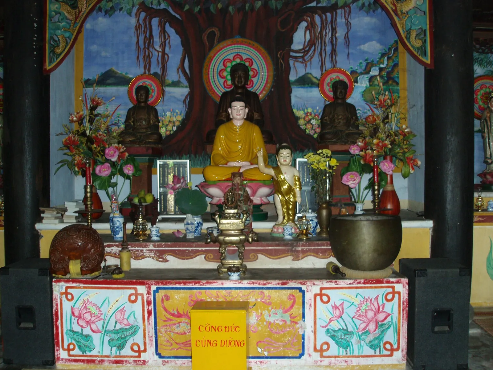 Main hall of Hai Tang Pagoda with Buddha statues and offerings on the altar