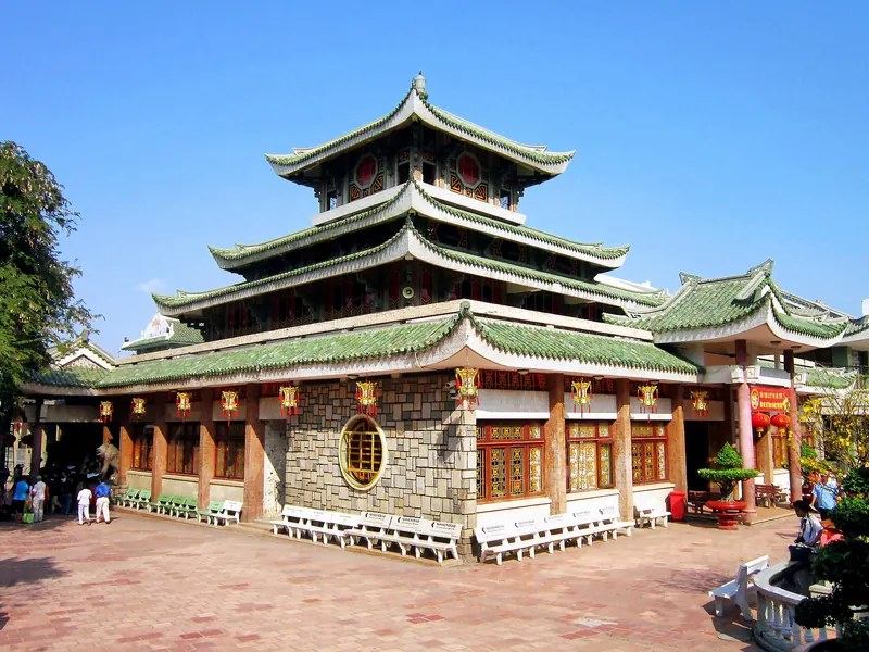 The tiered green-roofed temple of Ba Chua Xu at the foot of Sam Mountain under a blue sky