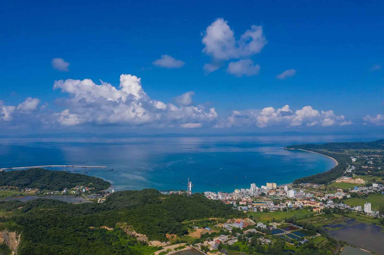 Aerial view of Co To town and its curving bay under a blue sky, Co To Island, Quang Ninh