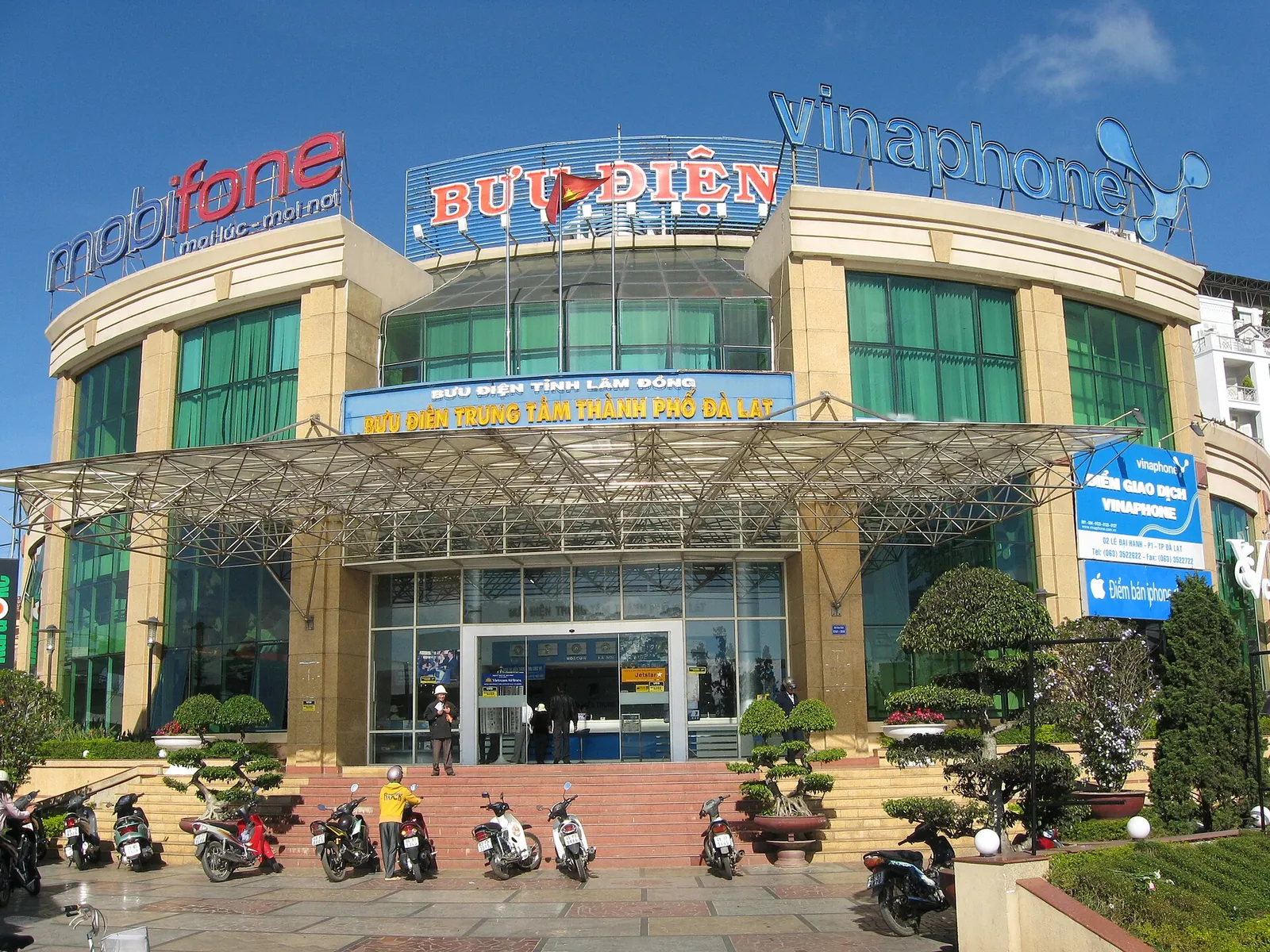 Da Lat Post Office building with MobiFone and VinaPhone signs on the roof and motorbikes parked by the steps