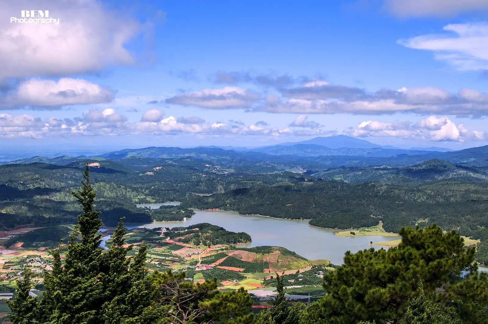 View from the top of Langbiang over pine forest, a lake and the hills of the Da Lat plateau