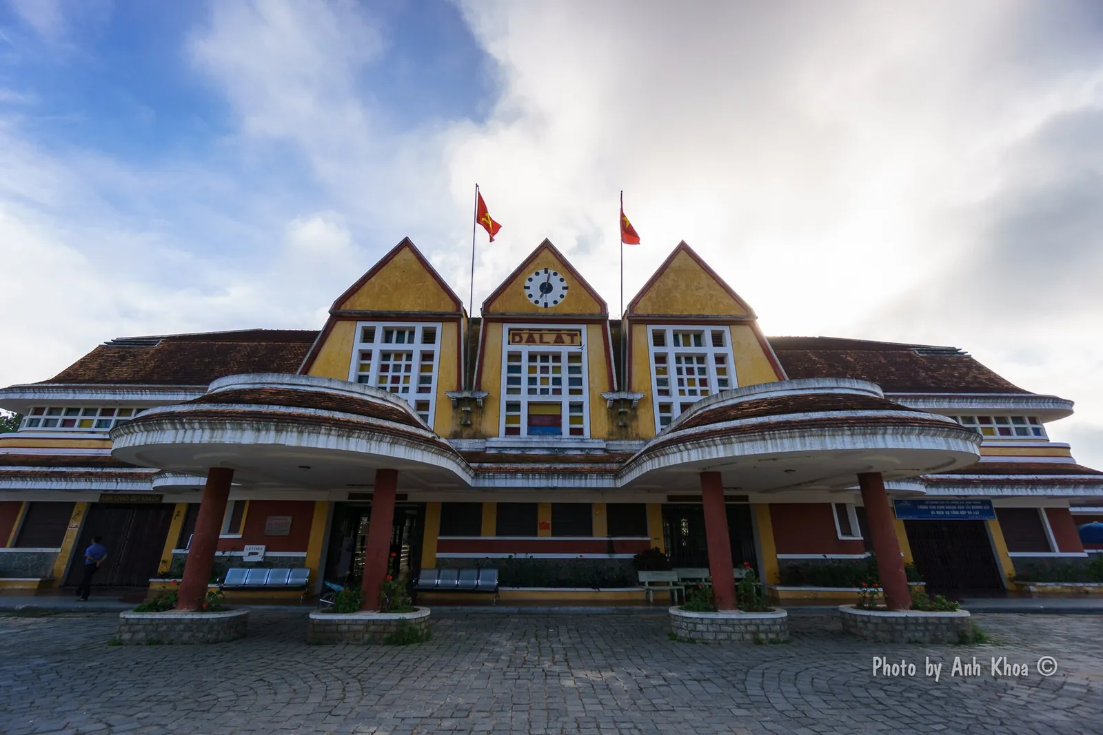 The yellow art-deco Da Lat railway station with its three peaked gables and flags on the roof
