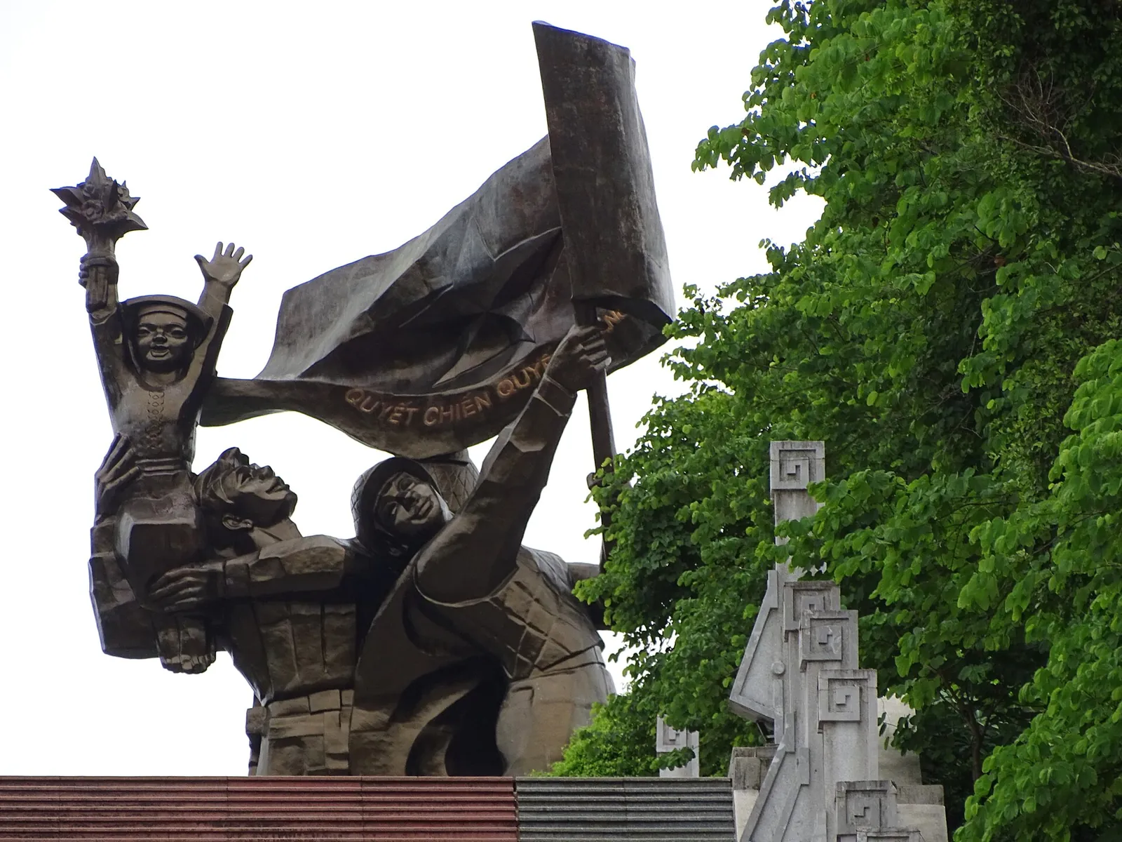 Bronze figures of three soldiers raising a flag at the Dien Bien Phu Victory Monument