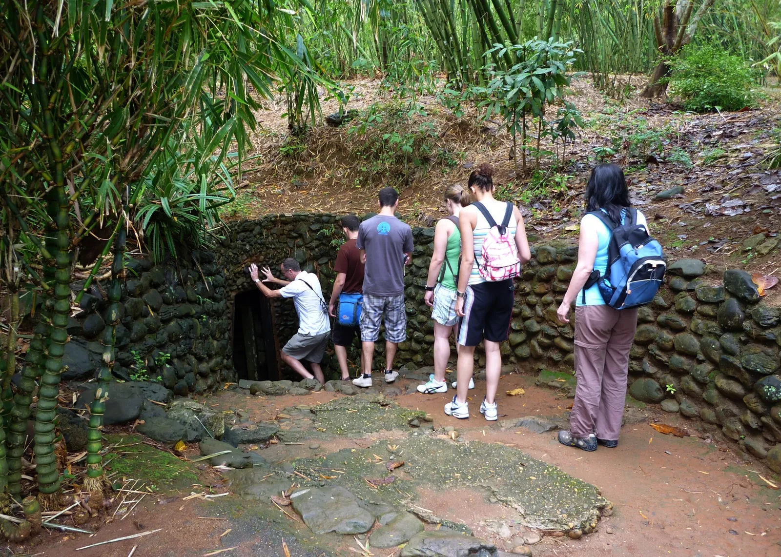 Visitors at a stone-lined entrance to the Vinh Moc tunnels among bamboo