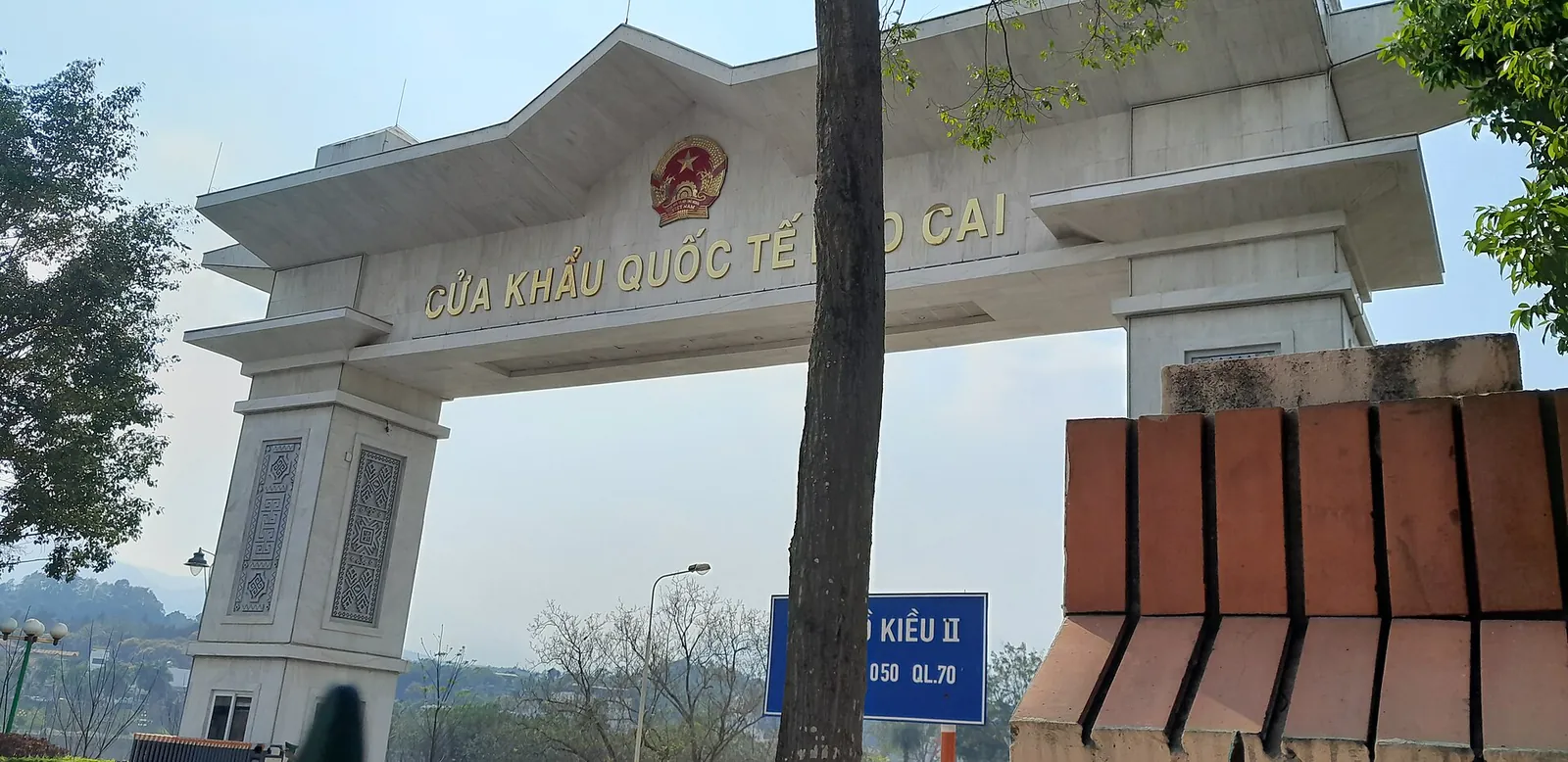 White ceremonial gate marked Cua khau quoc te Lao Cai at the Lao Cai international border crossing with China