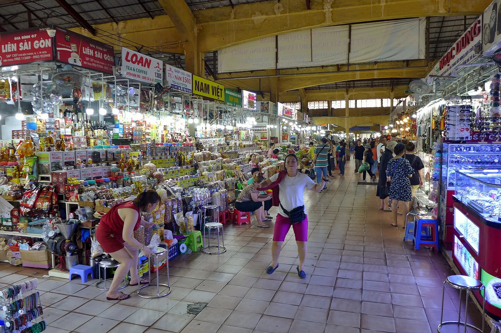 Long aisle of stalls selling dried goods, fruit and souvenirs inside Ben Thanh Market