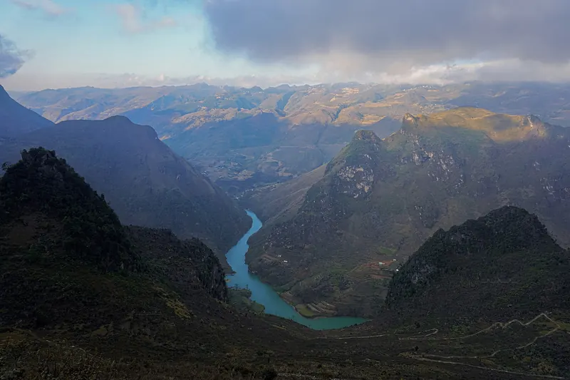 The turquoise Nho Que River winding through a deep green gorge between steep mountains