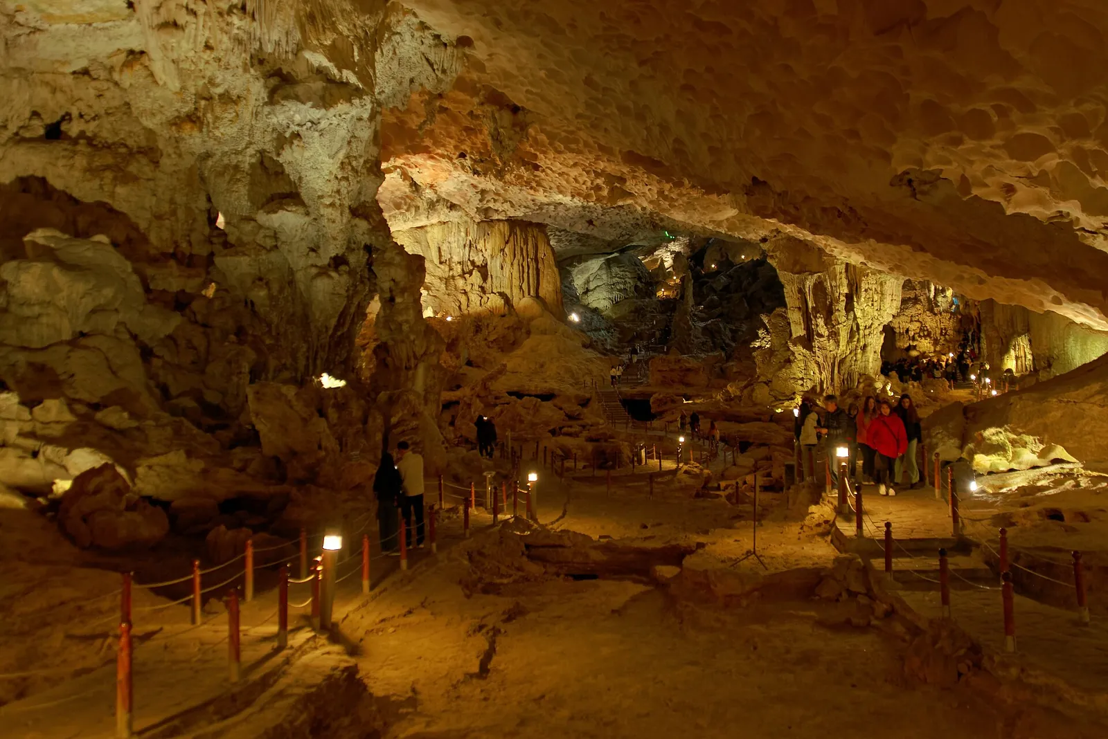 Lit walkway and stalactites inside the main chamber of Sung Sot Cave, Ha Long Bay