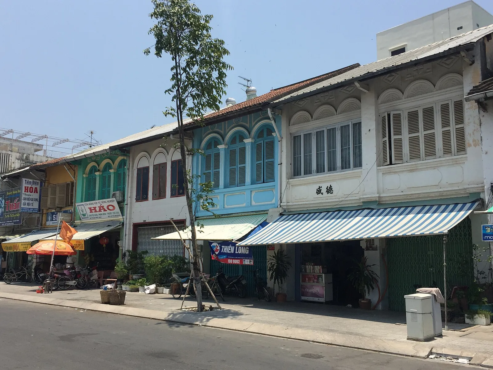 Pastel-coloured colonial-era shophouses with shutters and awnings on a main street in Ha Tien