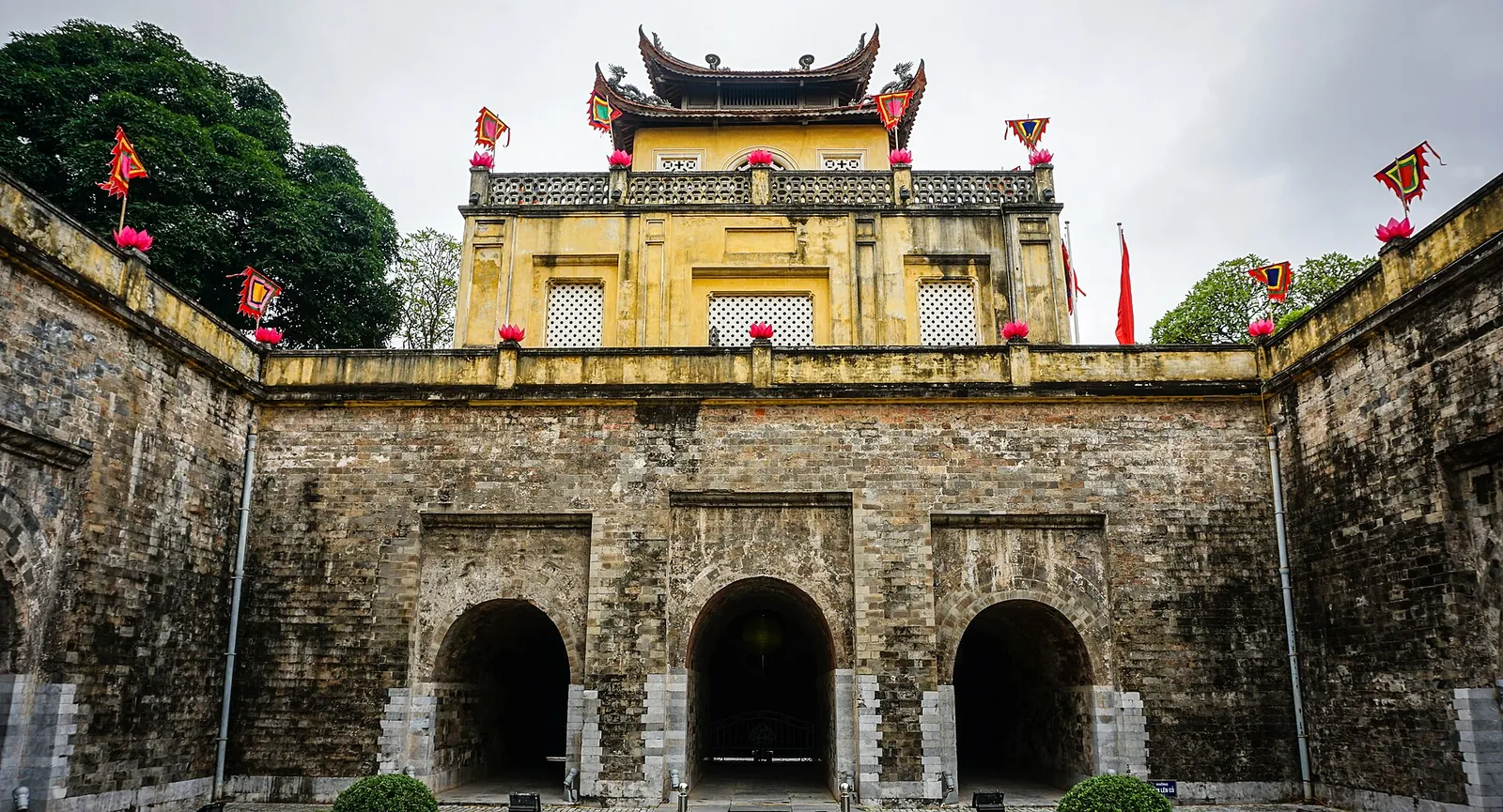 Yellow Doan Mon gate tower above stone arches at the Imperial Citadel of Thang Long