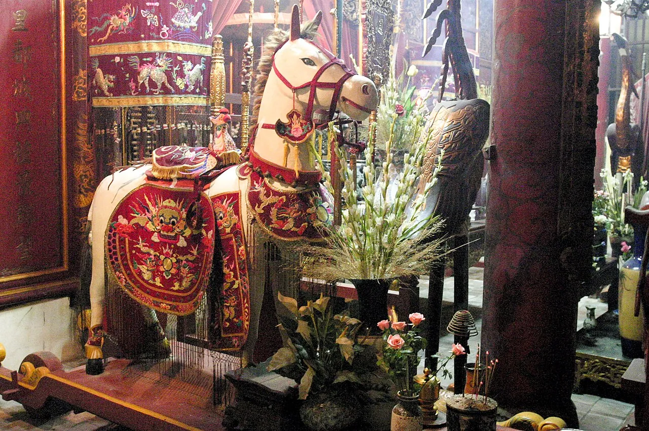 Statue of a white horse with a red saddle cloth inside Bach Ma Temple in Hanoi's Old Quarter