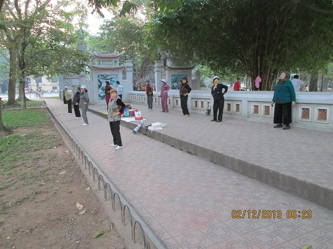 People doing tai chi and morning exercises on the path beside Ngoc Son Temple at Hoan Kiem Lake, Hanoi