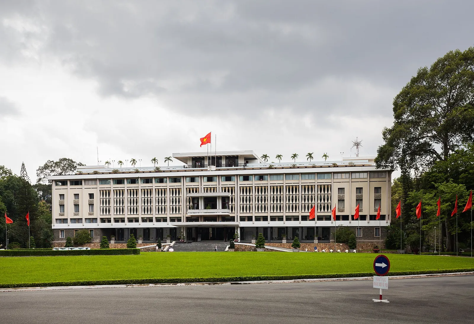 The modernist white Independence Palace behind its wide lawn under a cloudy sky, Ho Chi Minh City
