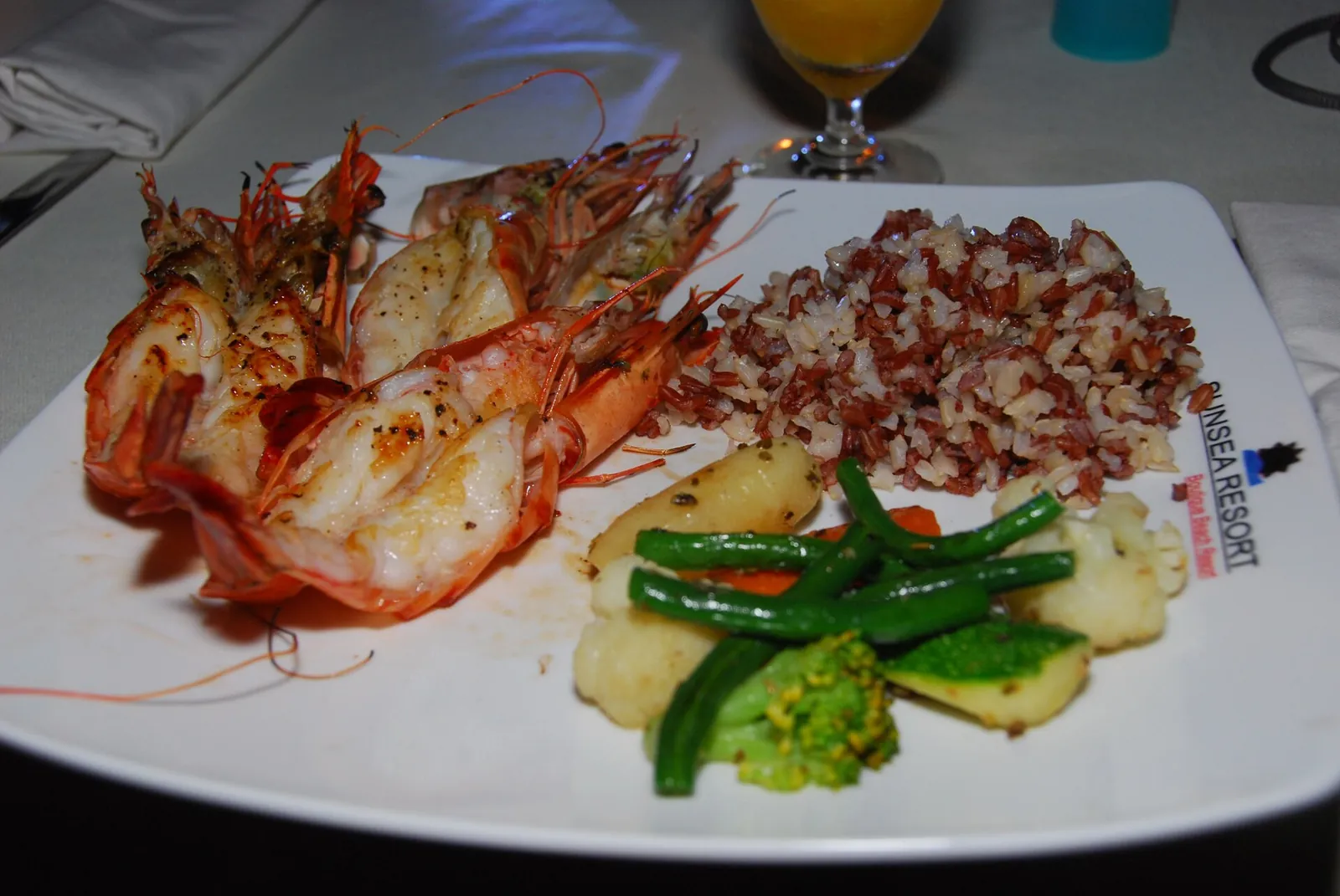 A plate of grilled giant prawns with potatoes and green beans at a restaurant on the Ham Tien strip in Mui Ne