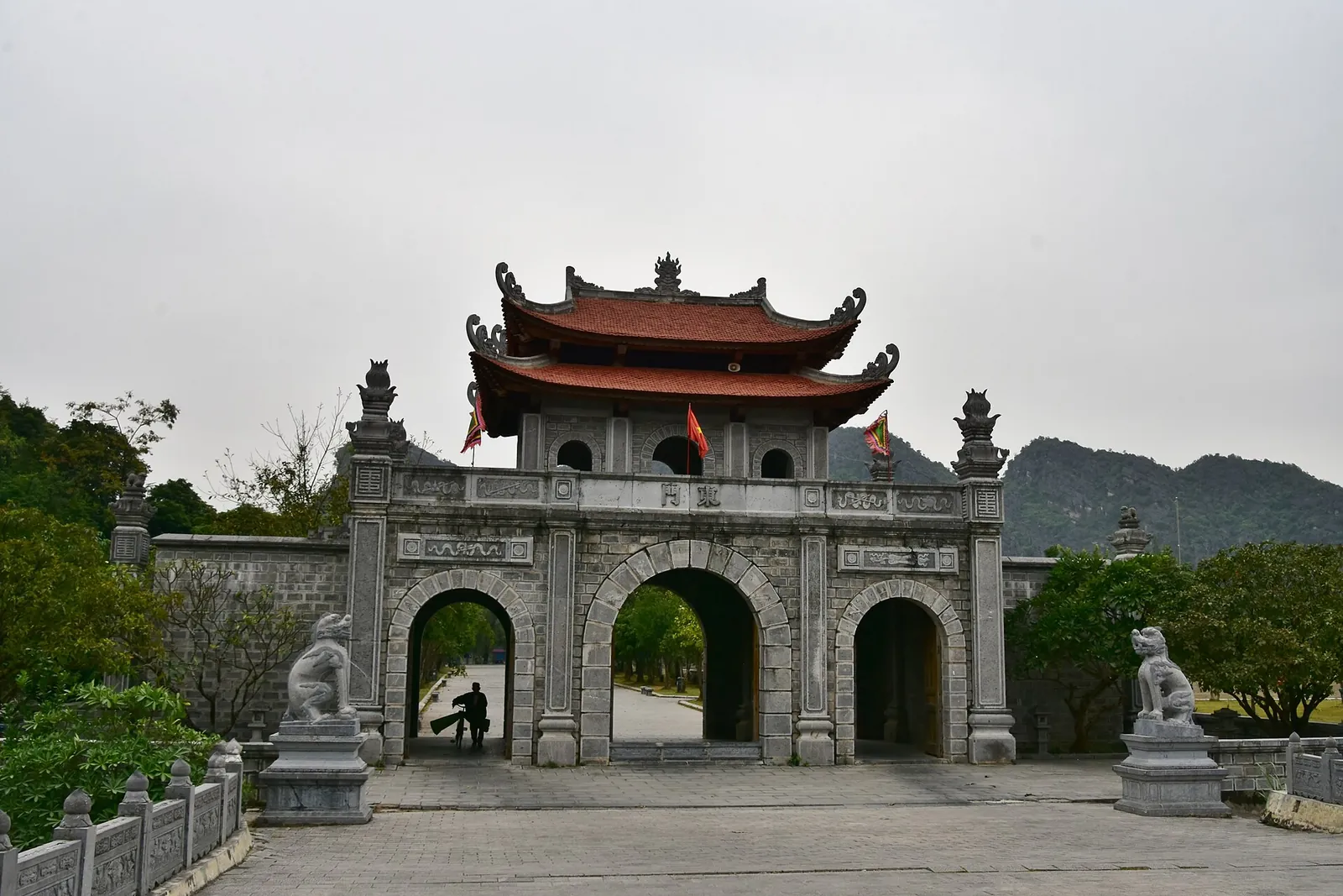 A stone triple-arched gateway with a tiled roof at the ancient capital of Hoa Lu
