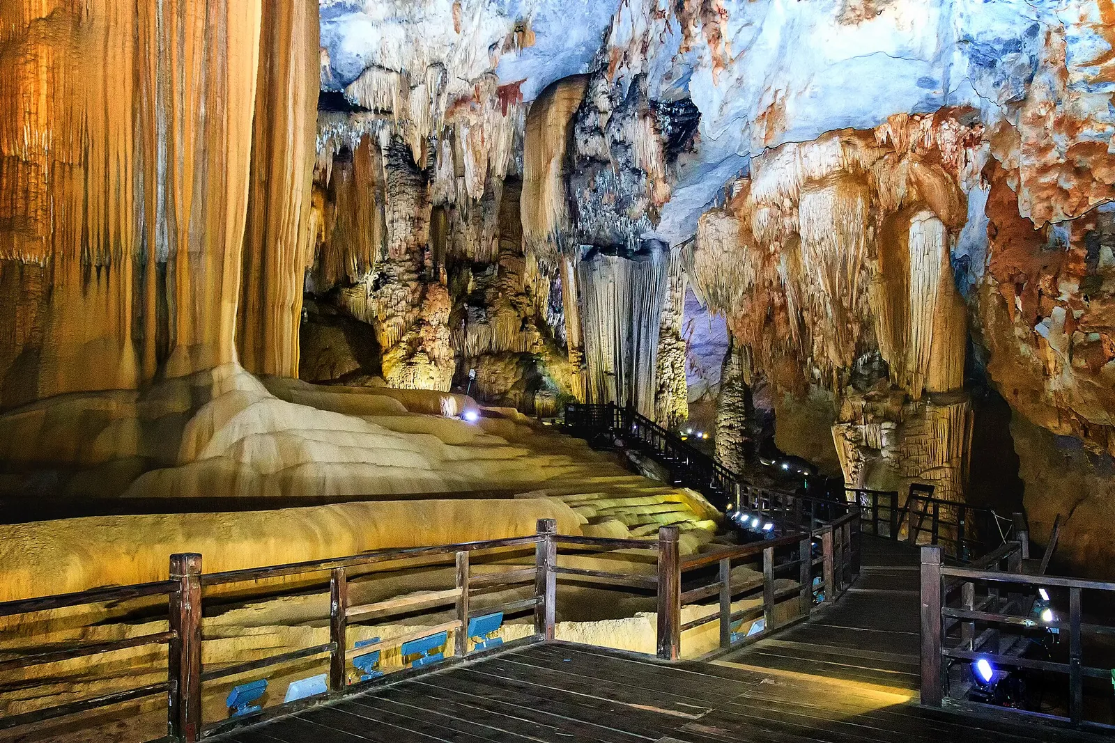 Wooden walkway winding between huge stalagmites and flowstone inside Paradise Cave