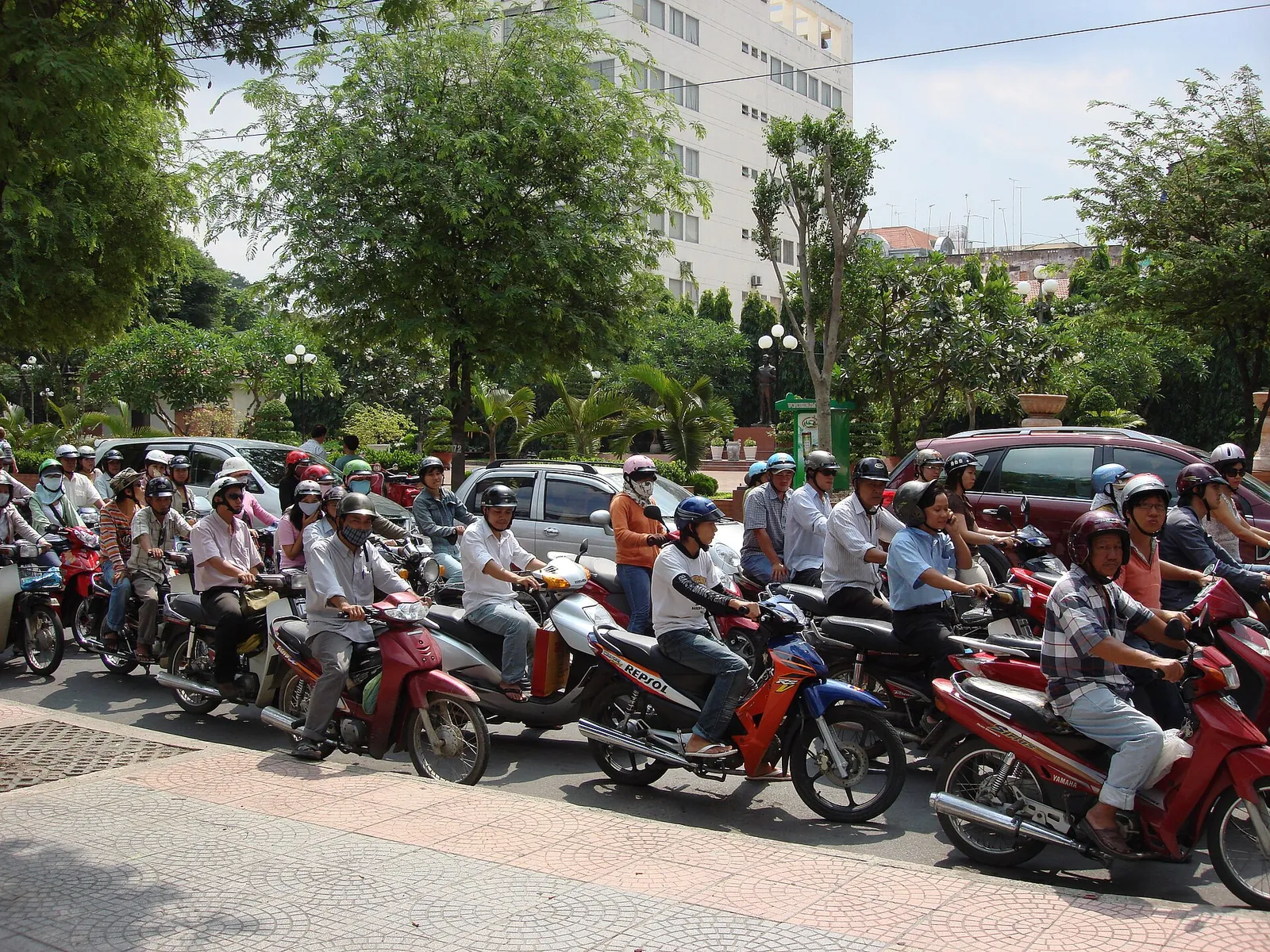 Rows of motorbikes and riders waiting at a junction in Ho Chi Minh City