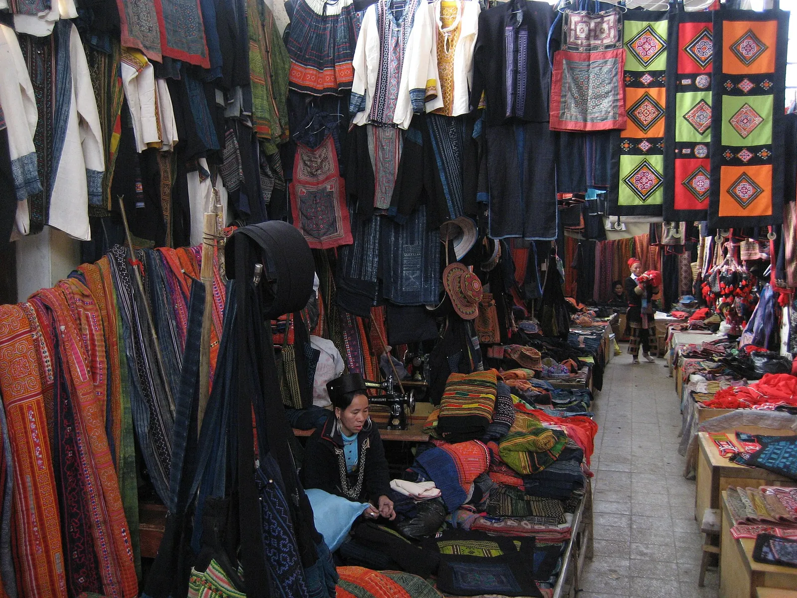 Indigo and embroidered textiles hanging at stalls inside the Sa Pa market