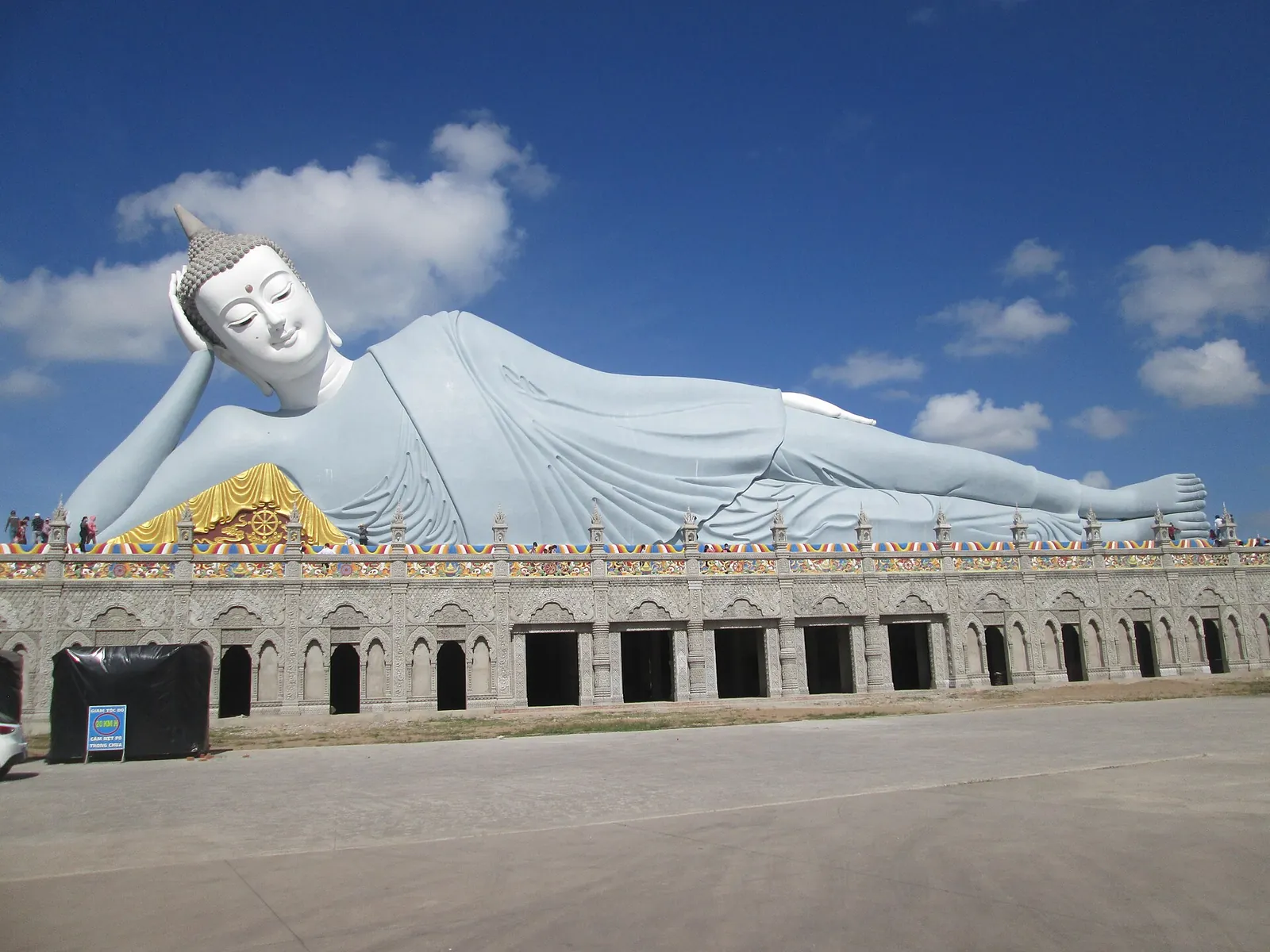 Giant white reclining Buddha lying on a long pedestal building at Som Rong Pagoda, Soc Trang