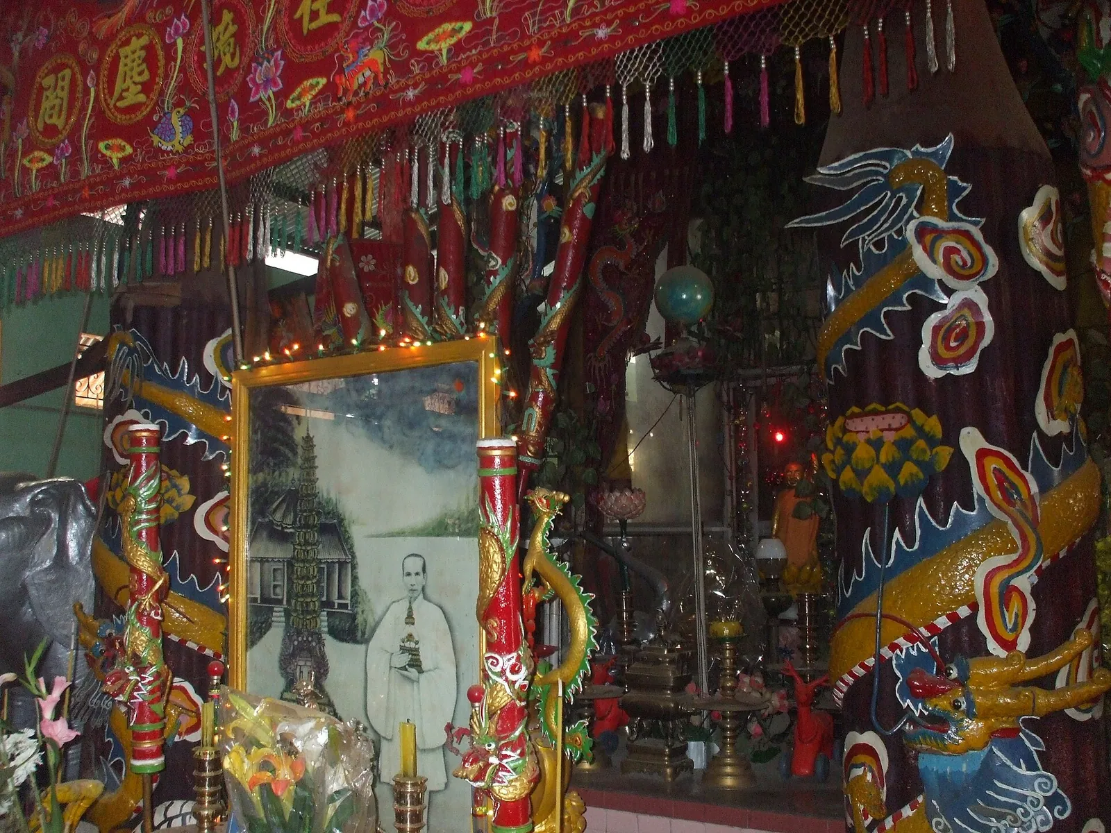Crowded altar inside the Clay Pagoda in Soc Trang with painted clay dragons and statues