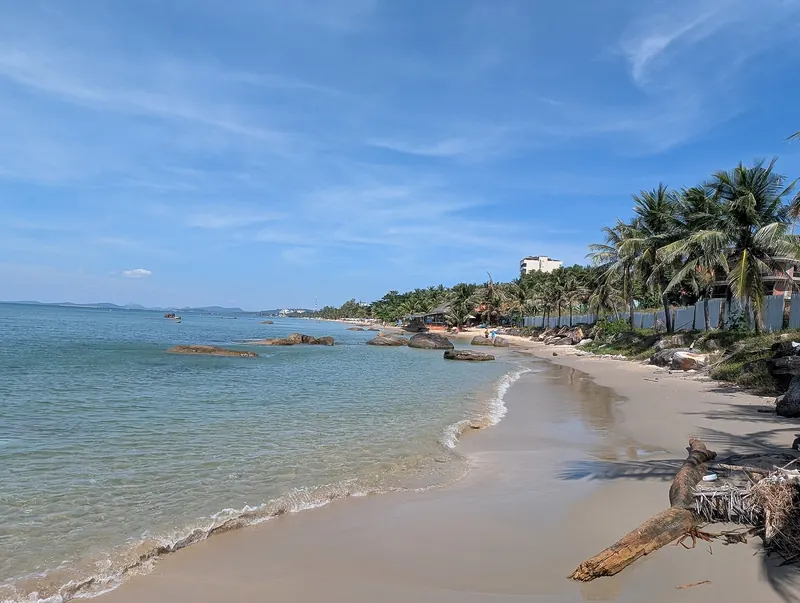 Palm-lined sandy beach and calm turquoise water on Phu Quoc under a clear blue sky