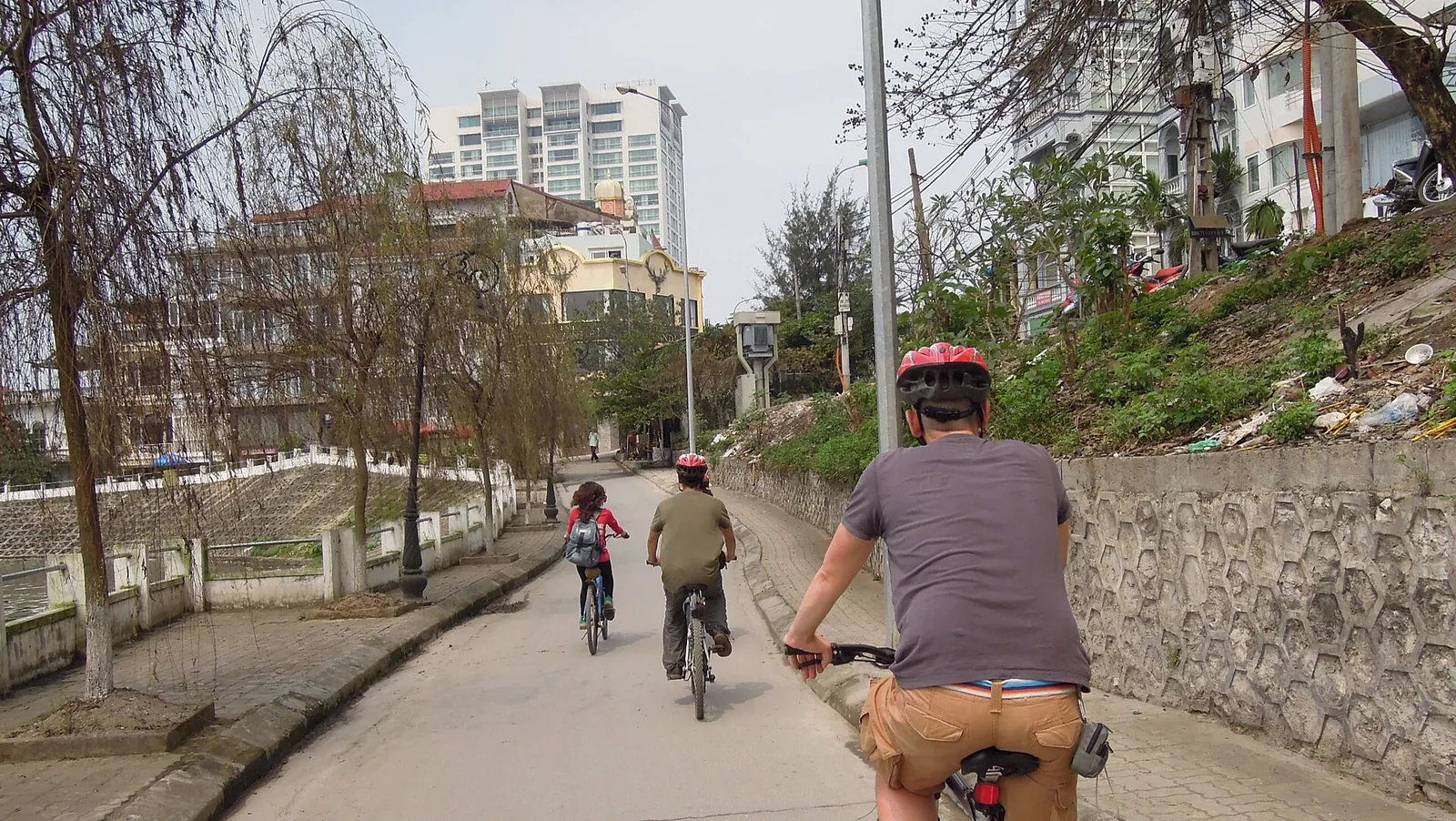 Cyclists riding along a quiet lane in Tay Ho, Hanoi