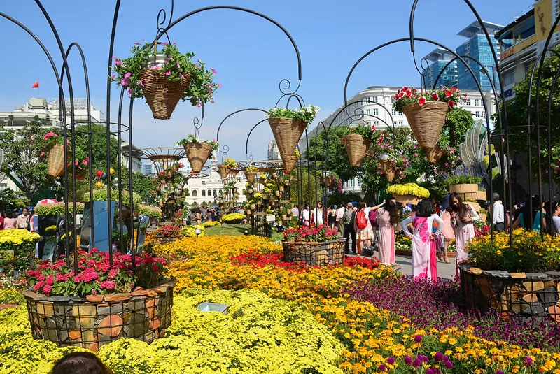 Beds of yellow and orange chrysanthemums and hanging flower baskets on Nguyen Hue Street in Ho Chi Minh City at Tet