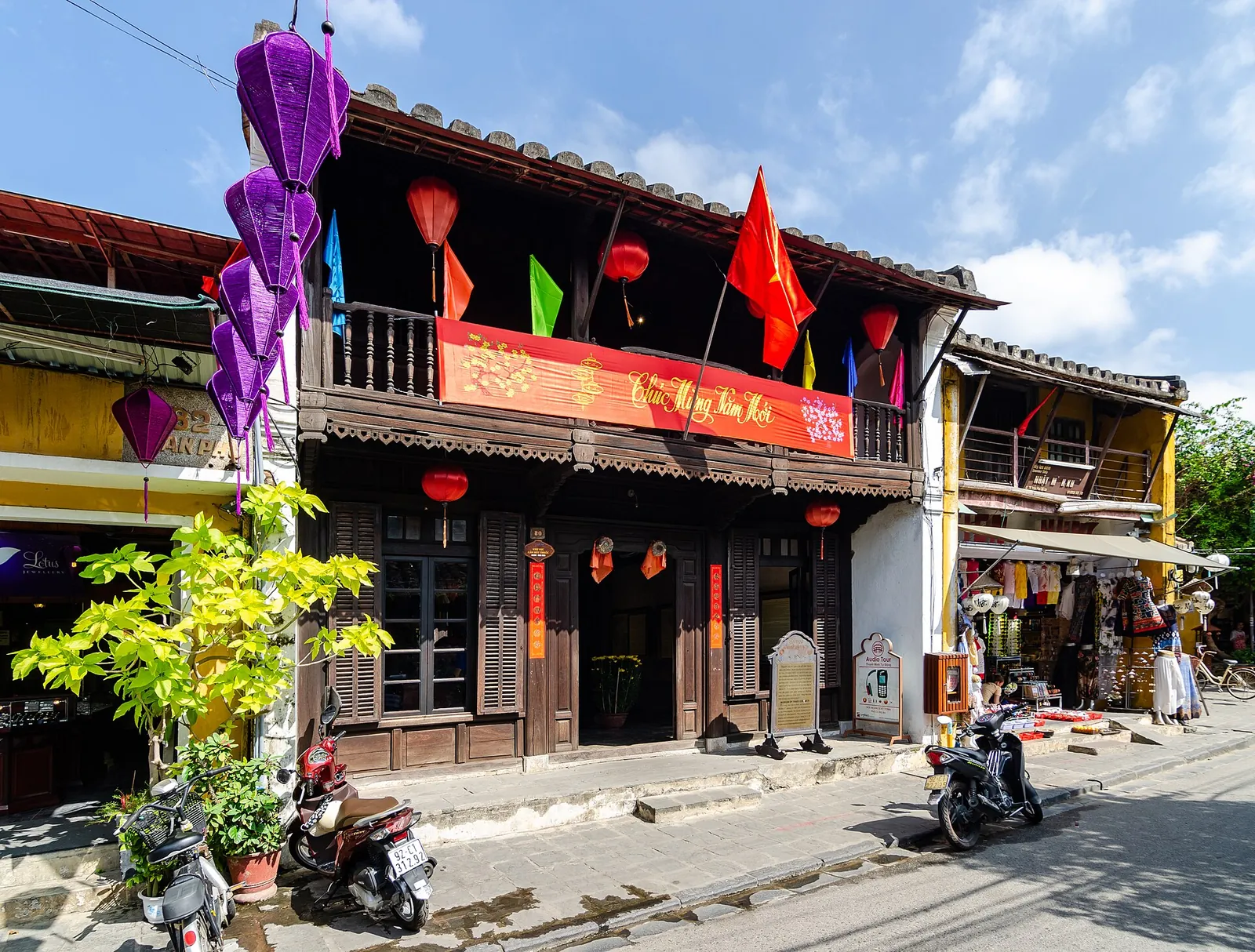 An old shophouse in Hoi An Ancient Town hung with red New Year banners, flags and lanterns