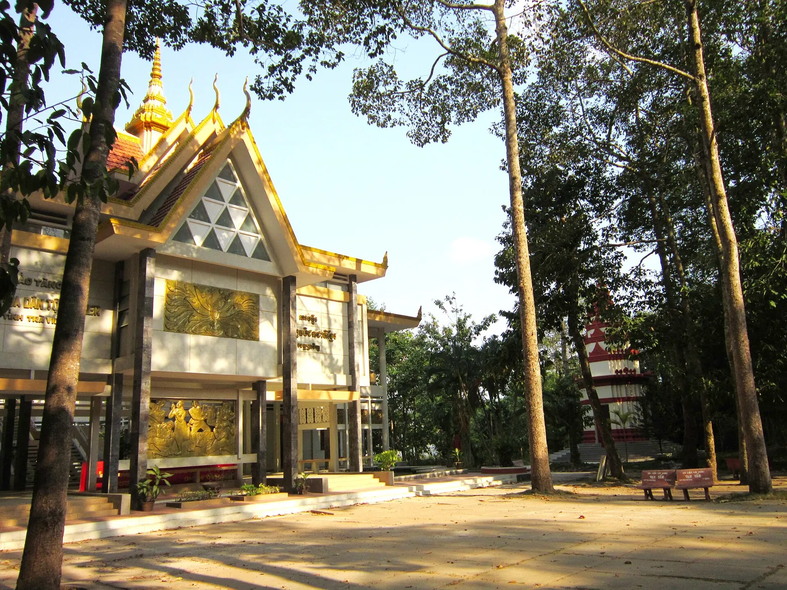 Museum of Khmer Ethnic Culture in Tra Vinh, a building with a pointed Khmer-style gable among tall trees
