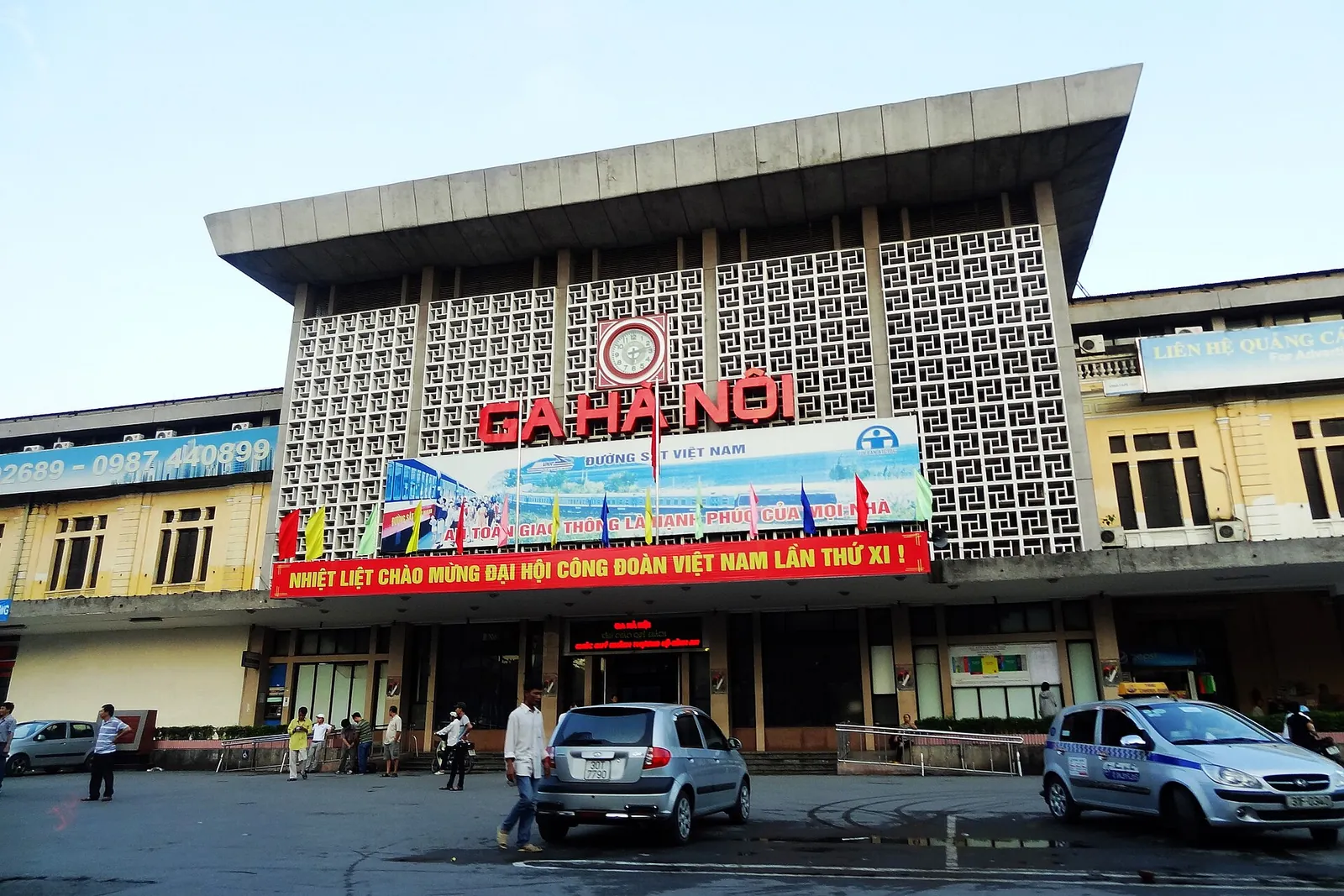The modern front of Hanoi Railway Station with taxis and motorbikes outside