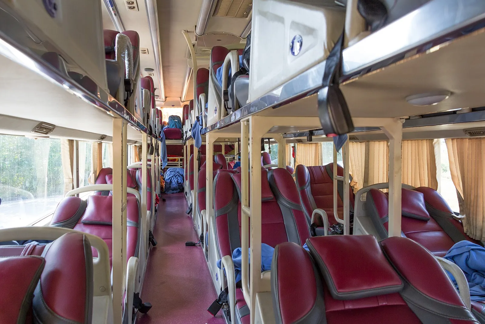 The aisle of a Vietnamese sleeper bus with two tiers of reclining berths