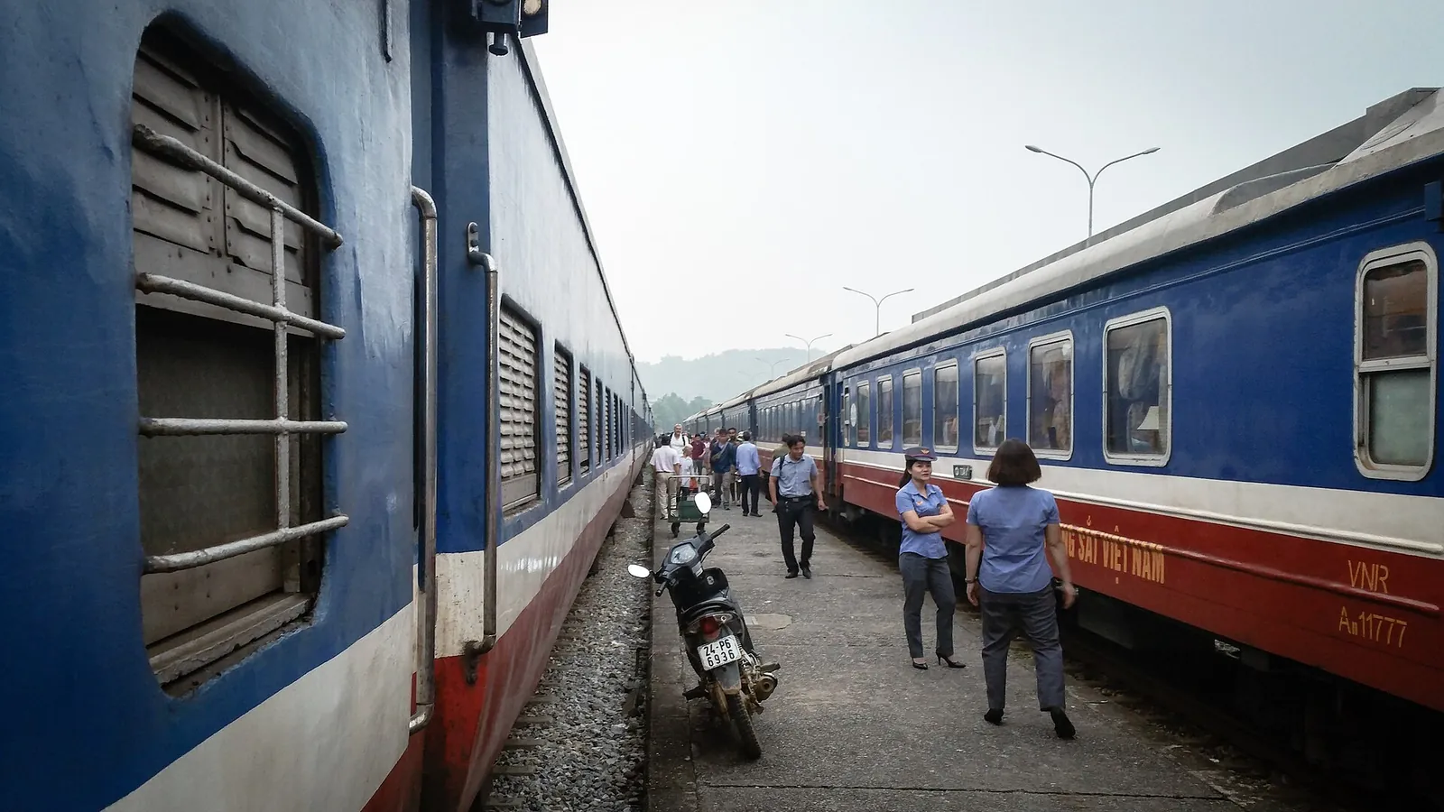Blue and white passenger carriages beside the platform at Lao Cai station