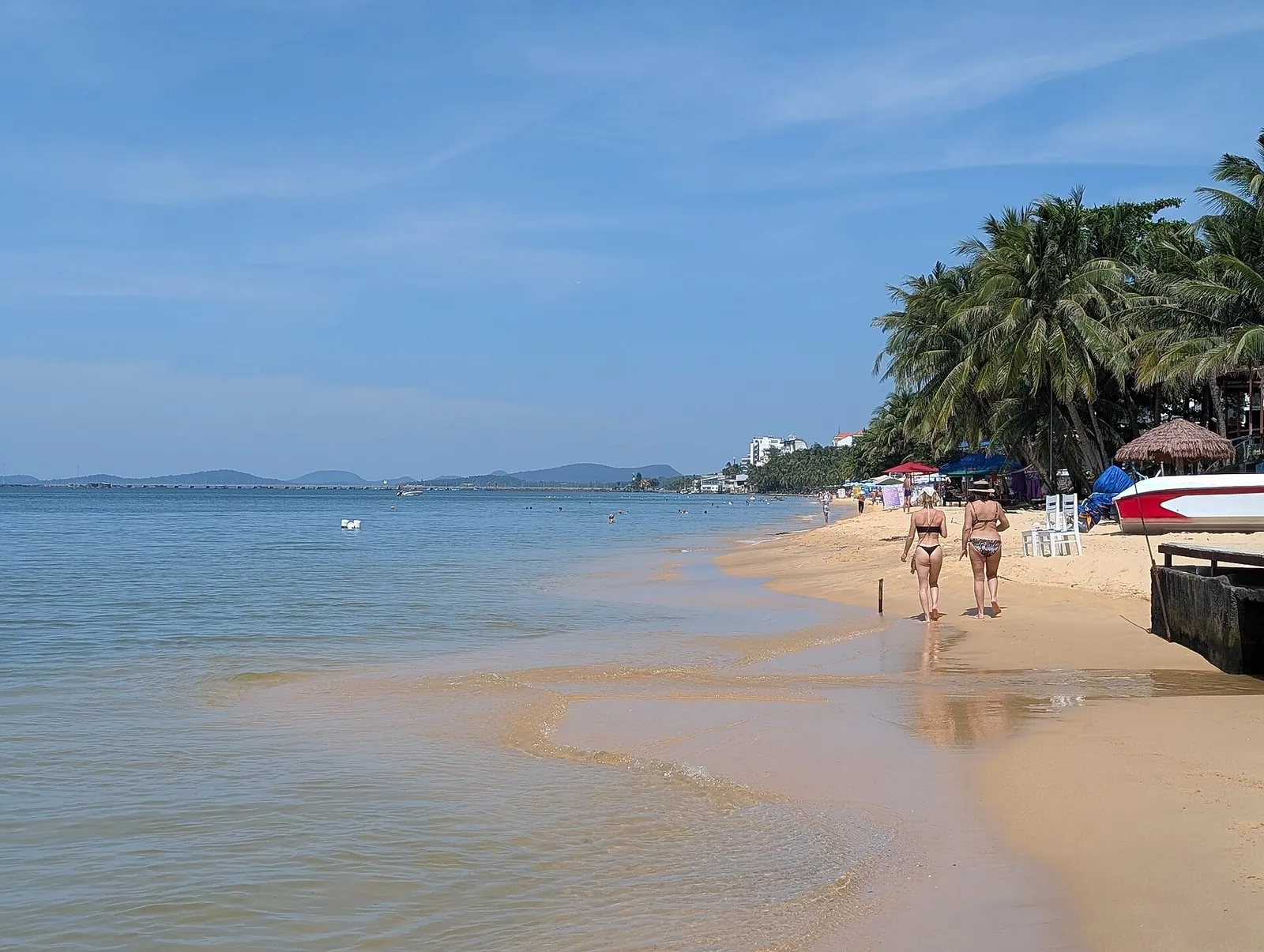 Shallow turquoise water and a sandy beach lined with palm trees on Phu Quoc