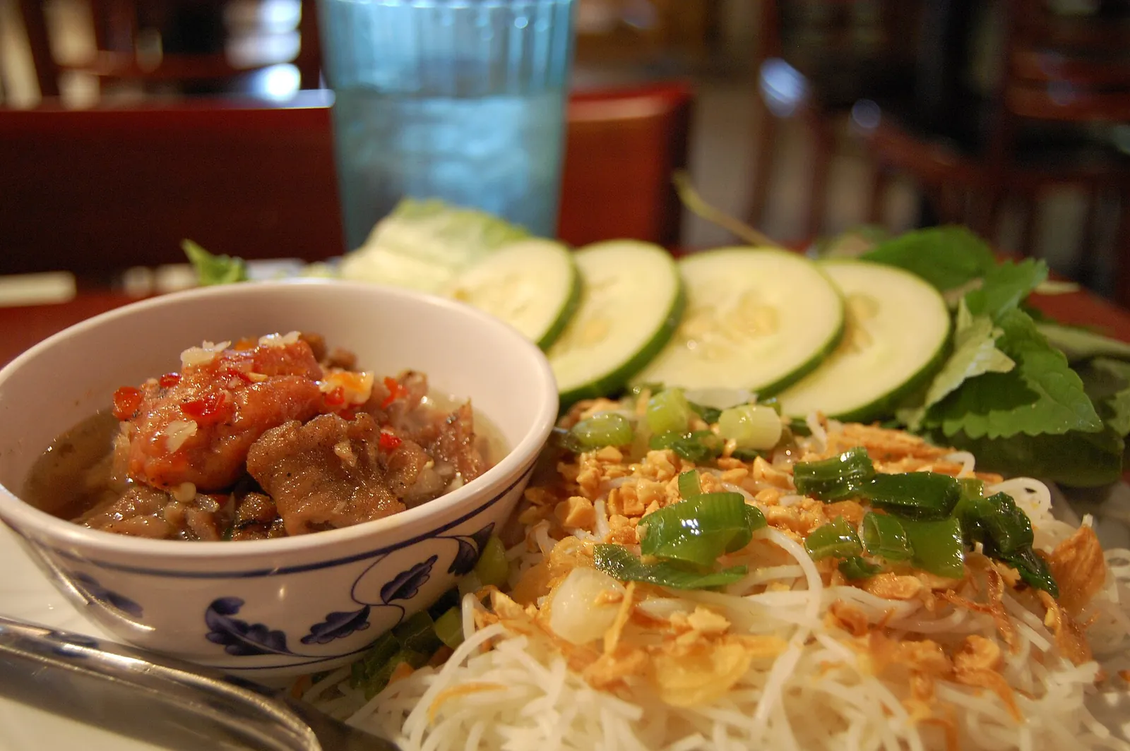 A bowl of grilled pork in broth with rice noodles, herbs and sliced cucumber, the Hanoi dish bun cha
