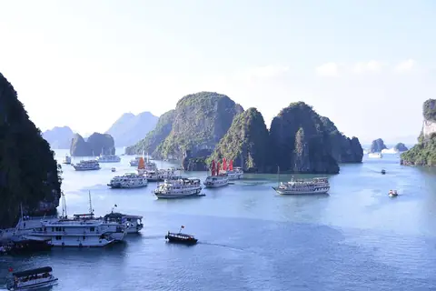 Limestone karst islands and cruise boats on blue water in Ha Long Bay, seen from the high point of Sung Sot Cave